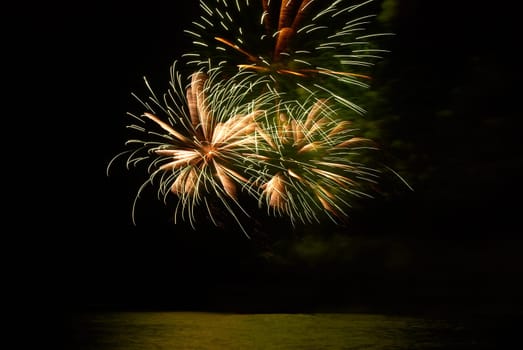 Yellow colorful holiday fireworks on the black sky background.