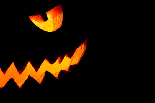 Big spooky helloween symbol has a glowing mad face and smiling with sharp teeth and bad look. Black orange nightmare of October 31st.