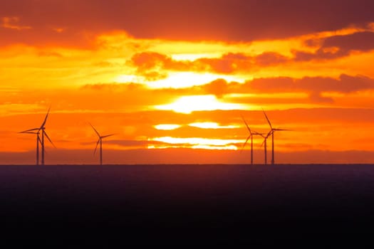 Many energy stations on sea water, clouds in the sky. Sustainable regenerative renewable industry business preventing climate change.
