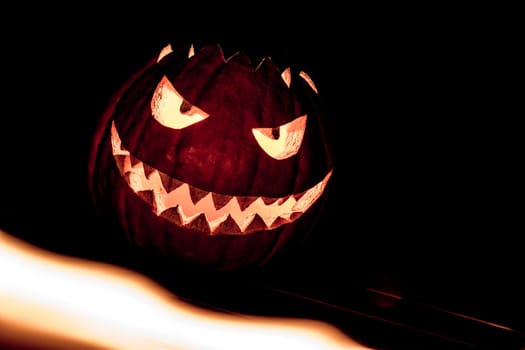Big helloween autumn symbol with mad face, glowing eyes, mouth and teeth. Scary hot nightmare horror with evil smile at october 31st.