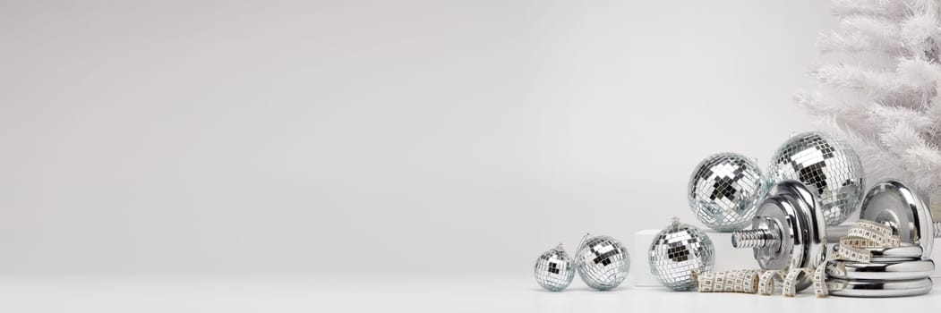 Dumbbells, Christmas fir tree and mirorr balls on white background with copy space. For design of advertising, web design. Christmas and New Year. Fitness, sport or healthy lifestyle concept.
