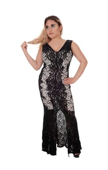 A gorgeous blond young woman standing in a long black evening dress.playing with her blond hair, isolated for white background.