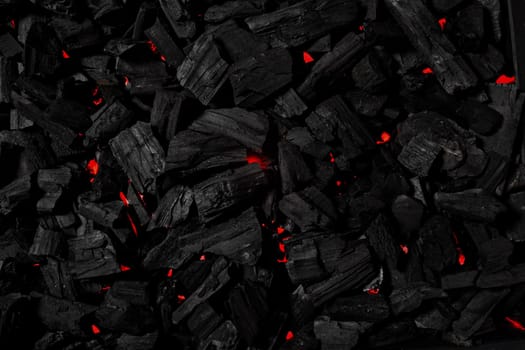 Black coal background illuminated with red light like fire underneath