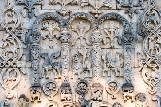 Big wall in church showing fictional characters. Primitive stone carving. Beautiful architecture of religious place. Tourist destination.