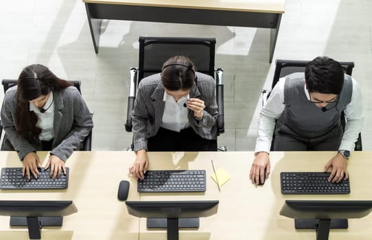 Top view of young adult friendly and confidence operator team agent with headsets working in a call center as customer service and technical support.