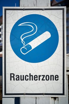 Sign with the inscription "Smoking zone"" in front of a hospital"