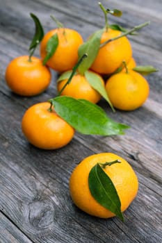 mandarin orange with leaf on wooden ground