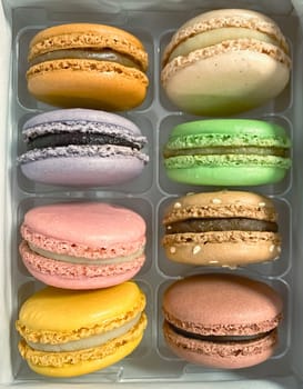 a group of colorful macarons stacked in a plastic package. Meringue-based dessert