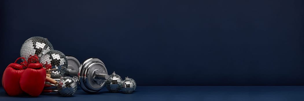 Dumbbell, boxing gloves, skipping rope, mirorr balls on dark blue background with copy space. For design of advertising, web design. Christmas and New Year. Fitness, sport or healthy lifestyle concept