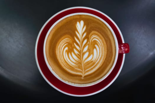 A cup of coffee on black table. Top view of coffee latte art. Drink and art concept.