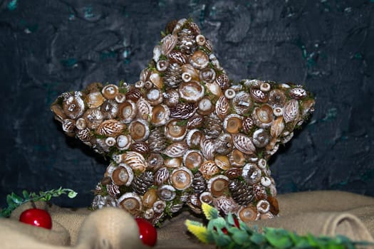 Handmade star decorated with cones and cranberries with christmas deer