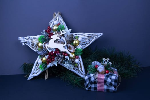 Handmade star decorated with cones and cranberries with christmas deer