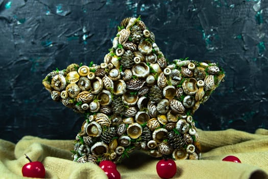 Handmade star decorated with cones and cranberries with christmas deer
