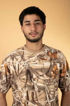 Standing young man on beige Background