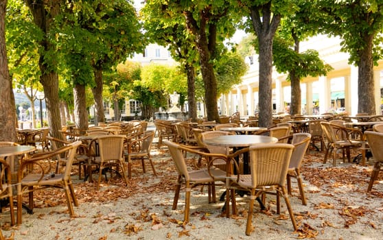 Empty chairs with tables in Park with autuumn leaves
