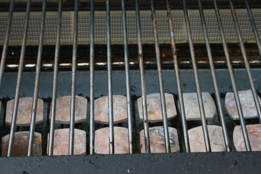 The grate of a gas grill with ceramic stones