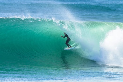 Surfing surfer rides inside hollow tubing ocean wave Durban South Africa