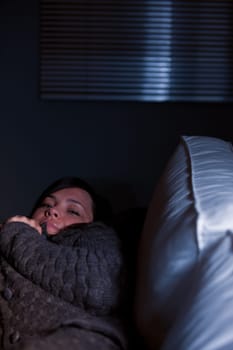 Girl sleeping on a couch in semi-darkness of her living room