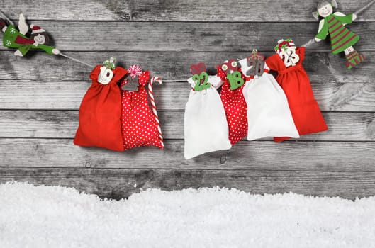 Hanging Colored Christmas Decoration with Santa Sacks, Candy Cane and Kids on Old Gray Wooden Wall.