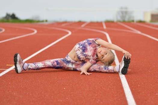 Girl in a pink legging doing splits at the stadium