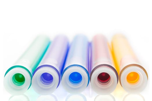 Colorful liquids, green, purple, blue, red and yellow, in test tubes with stoppers.