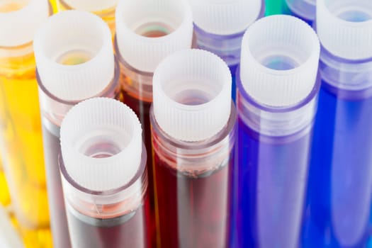 Colorful liquids, green, purple, blue, red and yellow, in test tubes with stoppers.