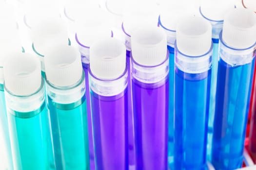 Colorful liquids, green, purple, blue, red and yellow, in test tubes with stoppers.