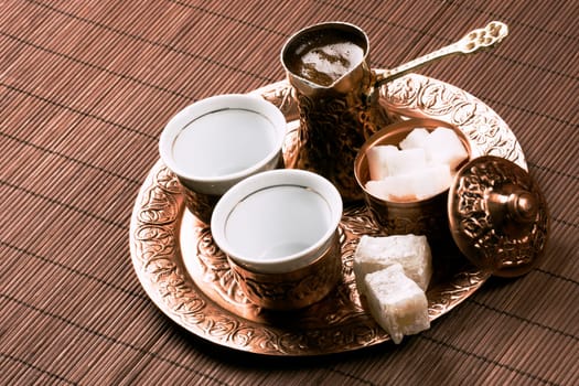 Traditional Turkish coffee set with two cups of coffee on table.