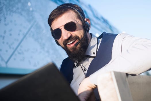 The virtual assistant or financial advisor with earphones and microphone is working online on laptop.