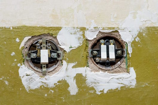 Two old electric switches mounted in the wall. The covers of switches is open.