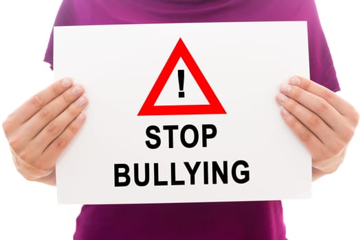 Girl holding white paper sheet with text Stop bullying