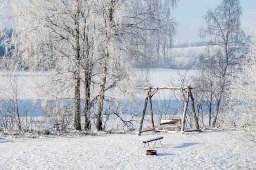A snow covered swings in the park