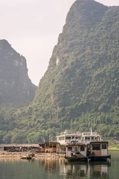 Yangshuo, China - August 2019 : Ferry waiting for passengers on the boat landing and ferry crossing in Yangshuo town, Guangxi Province