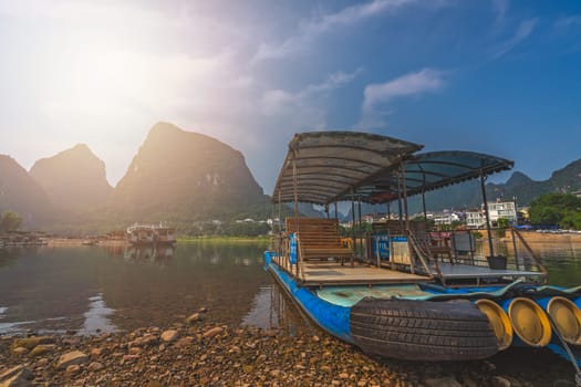 Yangshuo, China - August 2019 : Small tourist and fishermen boats on the Li river shore, the ferry crossing point in Yangshuo