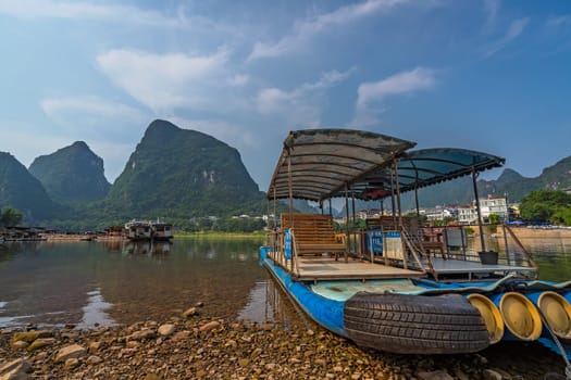 Yangshuo, China - August 2019 : Small tourist and fishermen boats on the Li river shore, the ferry crossing point in Yangshuo