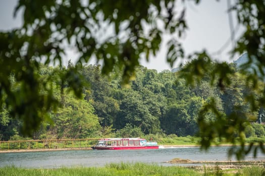 Guilin, China -  August 2019 : Small local passenger boat sailing on the magnificent Li river from Guilin to Yangshuo