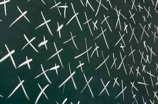 On blackboard with chalk drawn a lot of crosses