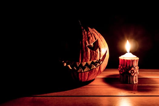Big helloween autumn symbol with mad face, glowing eyes, mouth and teeth. Scary hot nightmare horror with evil smile at october 31st.