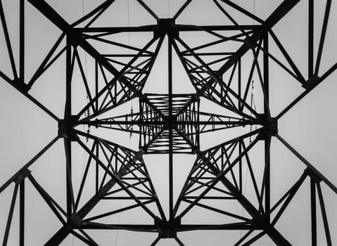 Underneath a truss pillar construction. Different geometric shapes, patterns of a steel structure. Metallic texture of an electricity pole.