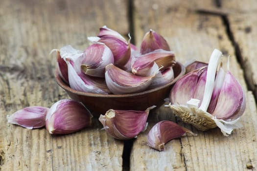 fresh garlic in a bowl - wooden background