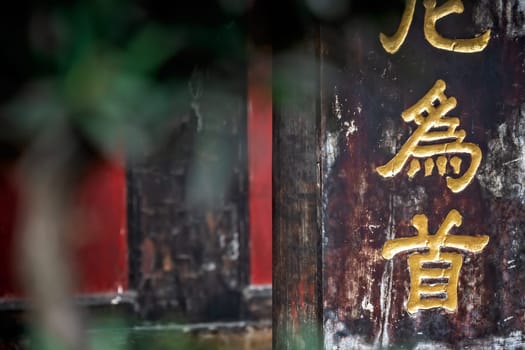 Golden chinese writing characters on a wall in the Wenshu Monastery, Chengdu, Sichuan Province, China