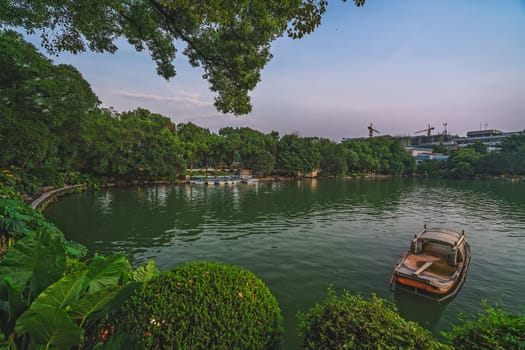 Small wooden boat moored on the shore of Shanhu or Shan Lake in Guilin town, Guangxi Province, China