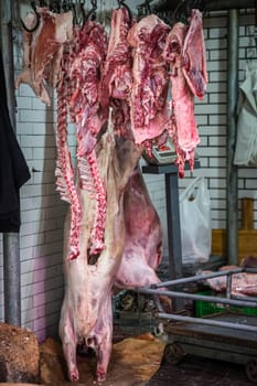 Xian, China -  August 2019 : Lamb and cow carcass meat hanging on a hook on the street food vendors shop in the Muslim quarter of Xian town, Shaanxi Province