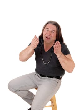 A close up image of a middle age indigenous man sitting on a chair.and blowing a kiss, isolated for white background.
