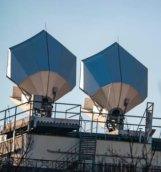 Satellite dish on the roof of the building against the blue sky. Technology. Place for text. Background image.