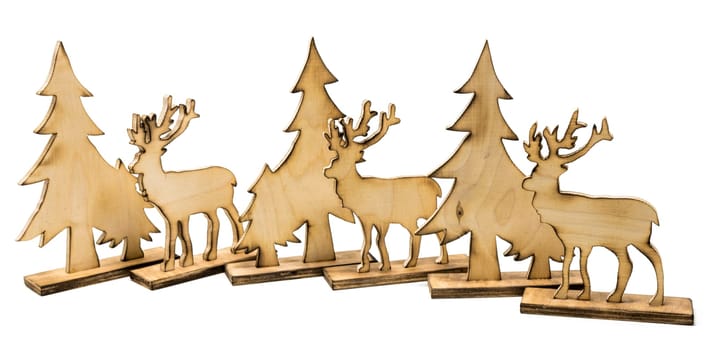 Cut out deer figure made of wood with dark edges and wooden fir trees isolated on white