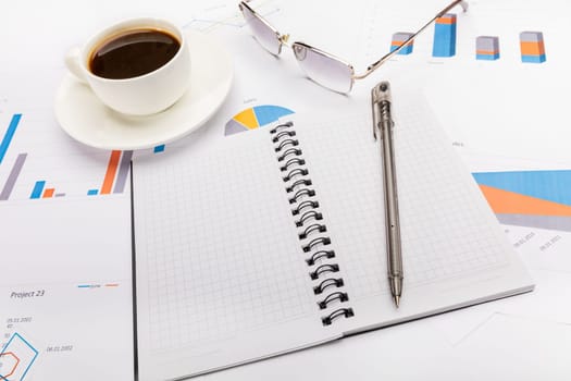 Notepad, a pen, coffee and glasses in business or school concept.