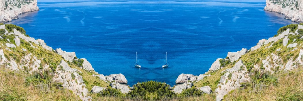 Panorama, secluded cove in picturesque Seascape with 2 sailboats on the island of Mallorca, Spain.