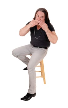 A image of a middle age indigenous man sitting on a chair.and blowing a kiss, isolated for white background.