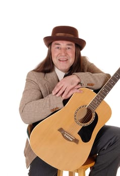 A middle age man sitting in a brown jacket and hat.and holding his beloved guitar, isolated for white background.